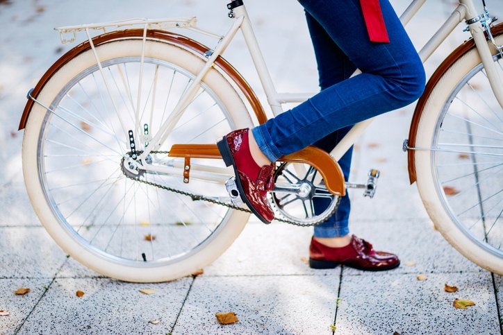 Close-up of a young woman with vintage red shoes and bicycle.