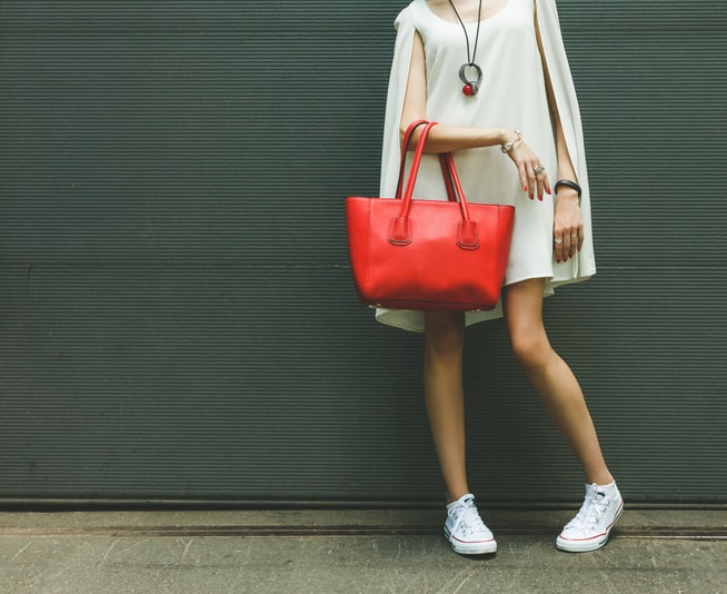 Fashionable big red handbag on the arm of the girl